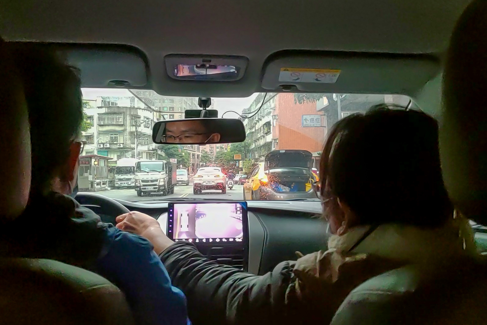 道路駕駛課程教學汽車臨停狀況,等待對向車道無來車,方向盤往左打閃過臨停車輛緩緩前進,輪胎稍壓黃線沒有關係,以順利通過